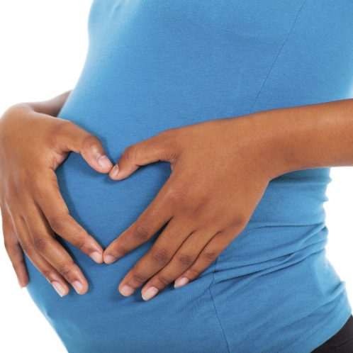 pregnant african american woman hands on belly forming a heart shape